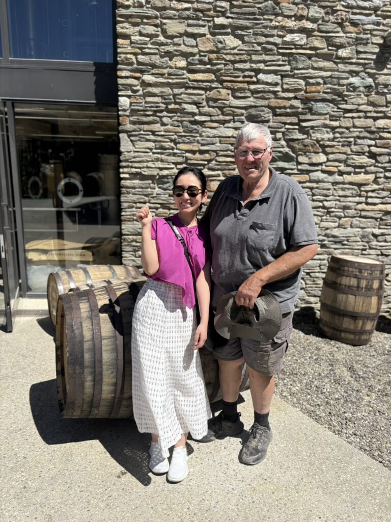 蒸留所の水源を自ら掘り当て、今も現役でフォークリフトを操り現場を支える創業者の父、アルヴィンさんと筆者の記念写真。家族経営の温かさが伝わる笑顔の2ショット