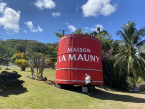 ラマニー蒸溜所にて。真っ赤なタンクの前で、バーリトルハピネスの谷本美香が微笑んでいる