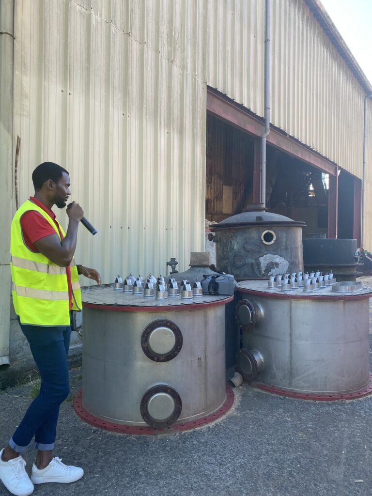 ラマニー蒸溜所にてバブルキャップの説明をするスタッフさん