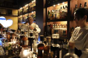 2026年4月26日、Bar Little HappinessにおけるLAODI 20周年記念テイスティング会の様子。カウンターに並ぶLAODI各種ボトルと20周年記念限定ボトルHAGUKUMU、バー専用チョコレート