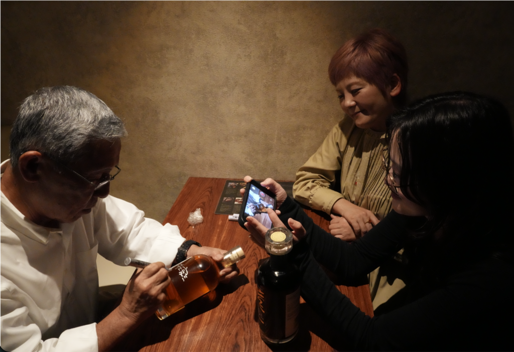 LAODI創業者・井上育三氏が、購入されたボトルにサインを入れる瞬間。Bar Little Happinessでの特別なテイスティング会にて