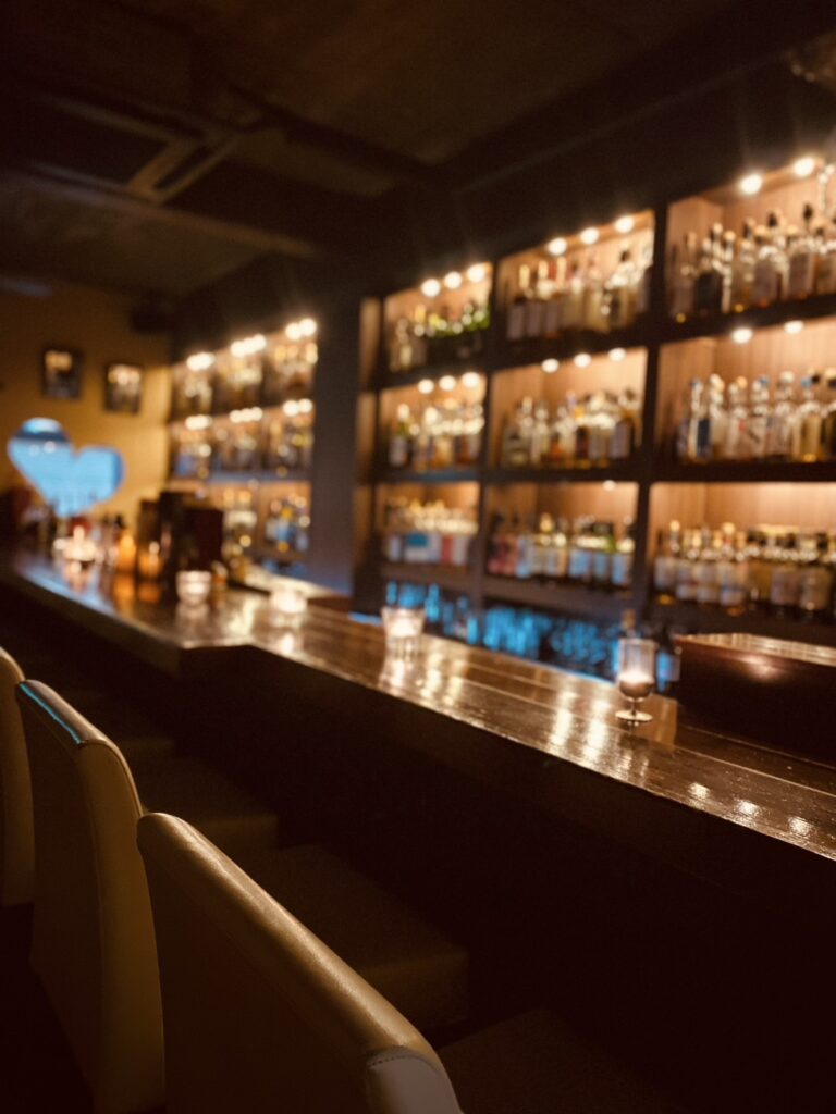 The counter at Bar Little Happiness, a whisky and rum bar in Hiroshima, lined with bottles