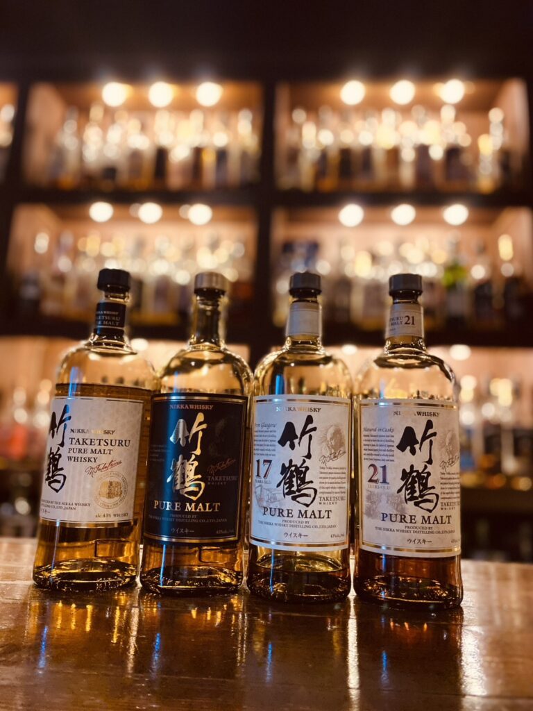 停產的竹鶴威士忌四支——舊版無年份黑標、17年、21年——並排陳列在廣島Bar Little Happiness吧檯上。