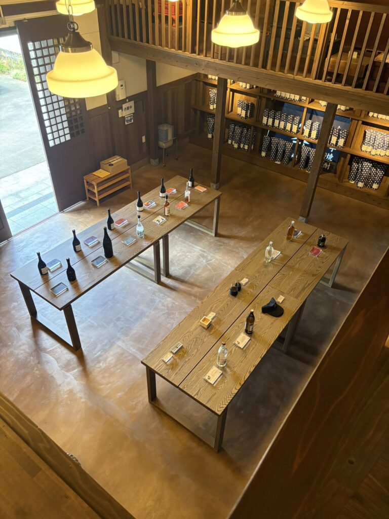 從上方俯瞰的品飲空間,木桌上擺著燒酎與蘭姆酒的酒瓶,日本鹿兒島指宿大山甚七商店