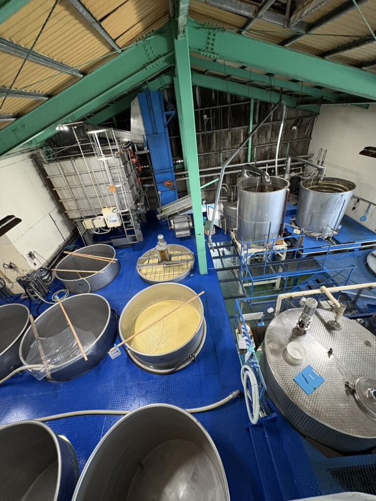 地面嵌著陶甕、以不鏽鋼槽發酵醪的發酵室,日本鹿兒島指宿大山甚七商店